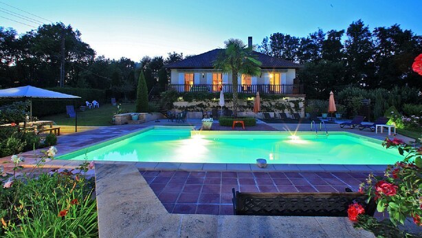 A swimming pool with a house in the background.