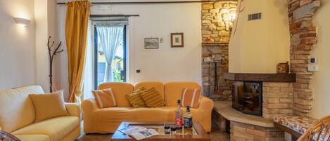 Una sala de estar acogedora con sofá, sillones, una mesa de centro y chimenea.