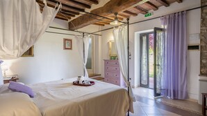 A bedroom with a bed, a nightstand, a dresser, and a window with curtains. - La Colonica 18, Emma Villas (Citerna)