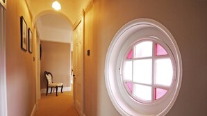 A hallway with a round window, a chair, and framed pictures on the wall. - Hot tub, beautifully restored Manse. Fantastic midweek rates available. (Stanley)