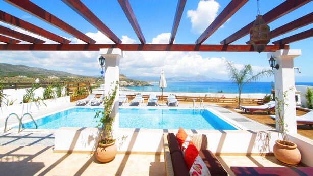 A rooftop pool area with lounge chairs and a view of the sea. - Detached Villa with Panoramic Sea Views in Beautiful Vlicha Bay, Lindos, Rhodes (Rhodes Island)