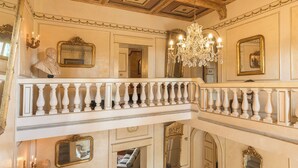 Un intérieur somptueux avec un balcon, des lustres richement décorés et un décor de style classique.