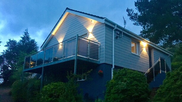 Une maison à deux étages avec un balcon et un petit porche.