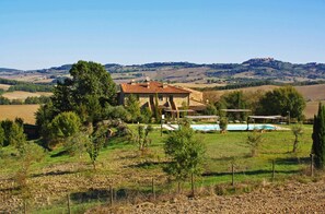 A stone villa with a tiled roof, a swimming pool, and a view of rolling hills in the background. - Roccaglia of Casale Refoli rural apartment 4 people (Casole d'Elsa)