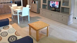 A modern living room with a dining area, a kitchen, and a TV in a cabinet. - Lovely apartment on Lake Garda in residence with pool (San Felice del Benaco)