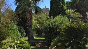 Un giardino con gradini in pietra che conducono a una zona relax bianca.