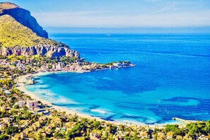 A coastal town with a beach, clear blue waters, and a mountainous backdrop. - Finocchiaro Penthouse - Terrace in the Center WiFi Free (Palermo)