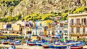 A coastal town with colorful buildings, a marina with boats, and a rocky hillside in the background. - Finocchiaro Penthouse - Terrace in the Center WiFi Free (Palermo)