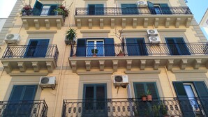 A multi-story building with balconies, air conditioning units, and potted plants. - Finocchiaro Penthouse - Terrace in the Center WiFi Free (Palermo)