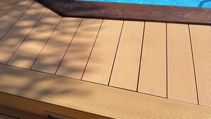 Una piscina con un pontile in legno e una vasca idromassaggio.