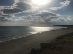 A beach with the sun setting over the horizon, a clear sky, and a distant shoreline. - EXCLUSIVE - 20 min Rome, few min from the sea, villa with private pool (Ladispoli)