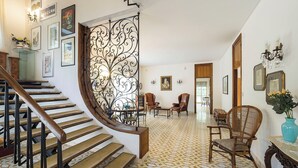 A spacious living area with a wooden staircase, a decorative metal partition, and a patterned floor. - Villa with pool and stunning views, 22 sleeps! (Trecastagni)
