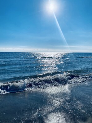 Una vista despejada del océano, con el sol reflejándose en el agua.