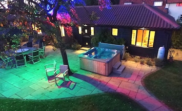 Outdoor area, including hot tub, in the evening