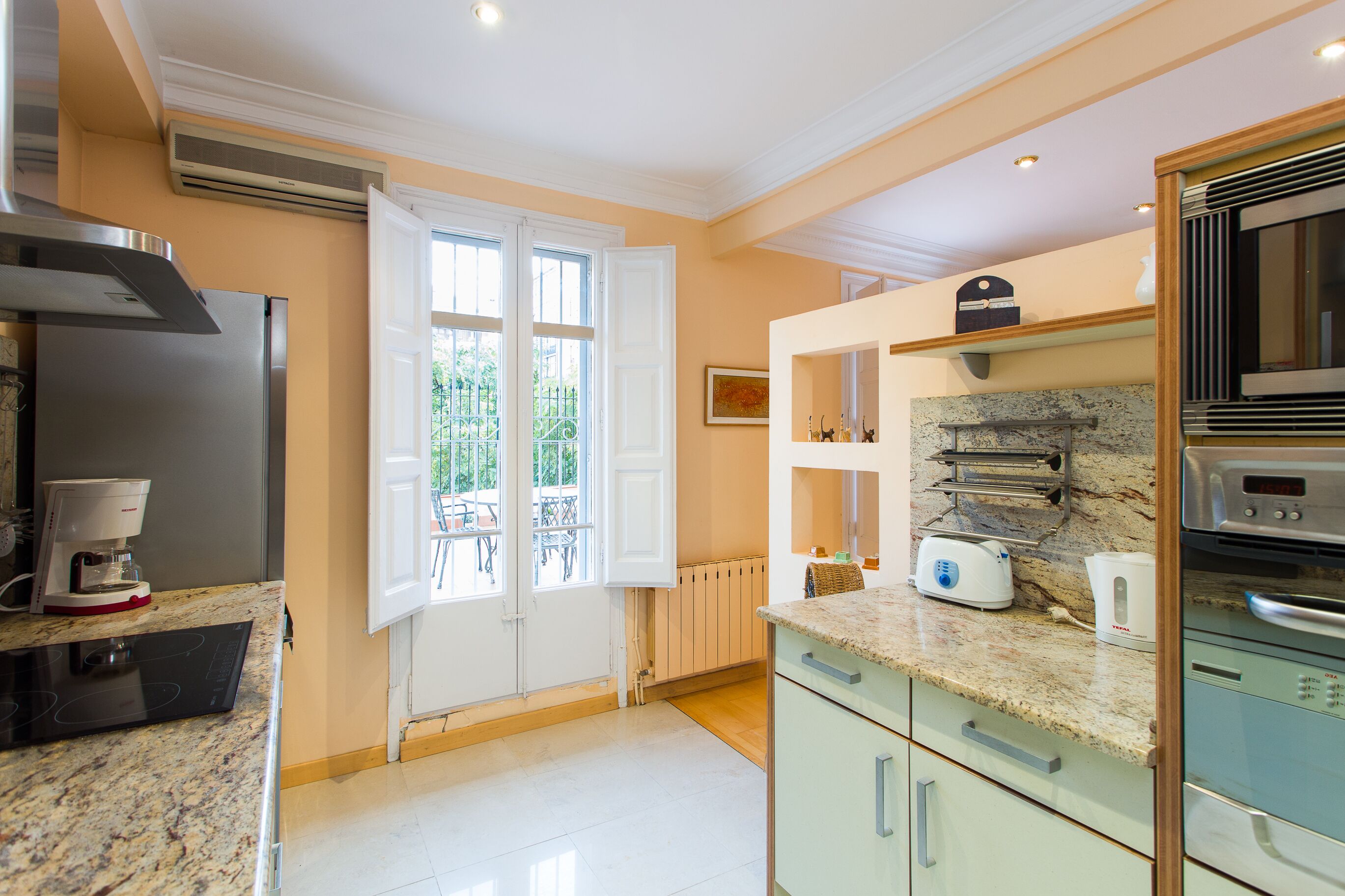 A modern kitchen with a refrigerator, stove, microwave, and coffee maker.