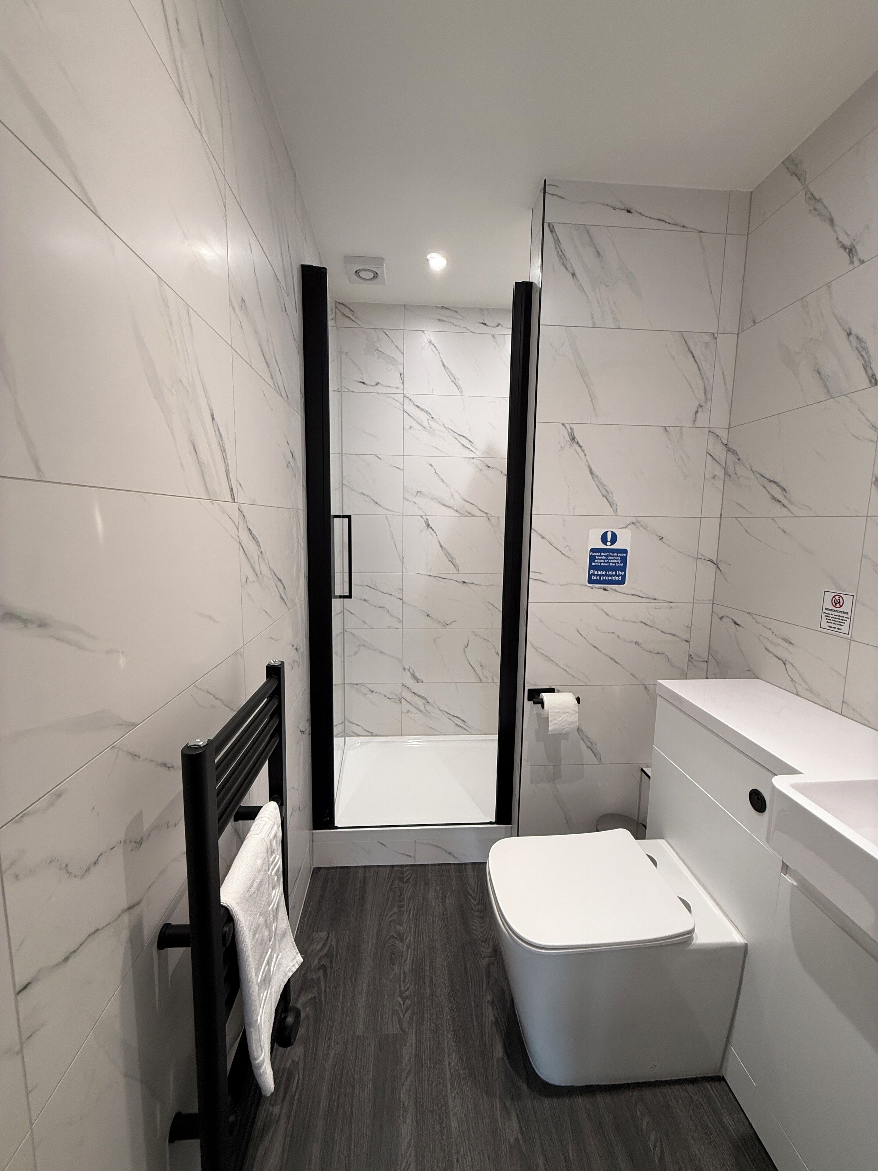 Une salle de bain moderne équipée d’une douche, de toilettes et d’un lavabo.