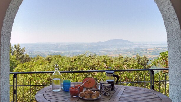 A balcony with a table set for a meal, overlooking a scenic landscape with hills and trees. - Total Peace, Quiet And Privacy In A Breathtaking Mountainside Location Near Rome (Poggio Catino)
