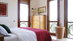 A bedroom with a bed, a wooden dresser, and a window with a view of greenery. - Total Peace, Quiet And Privacy In A Breathtaking Mountainside Location Near Rome (Poggio Catino)