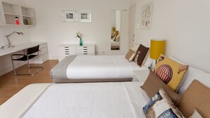 Ein modernes Schlafzimmer mit einem großen Bett, einem Schreibtisch, einem Stuhl und einer Kommode.