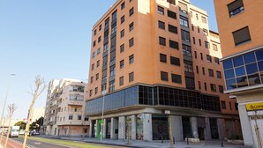 A multi-story building with a modern architectural design, featuring a mix of glass and brick facades. - PENTHOUSE, TERRACE ON THE HORIZON OF ALMERIA (Almería)