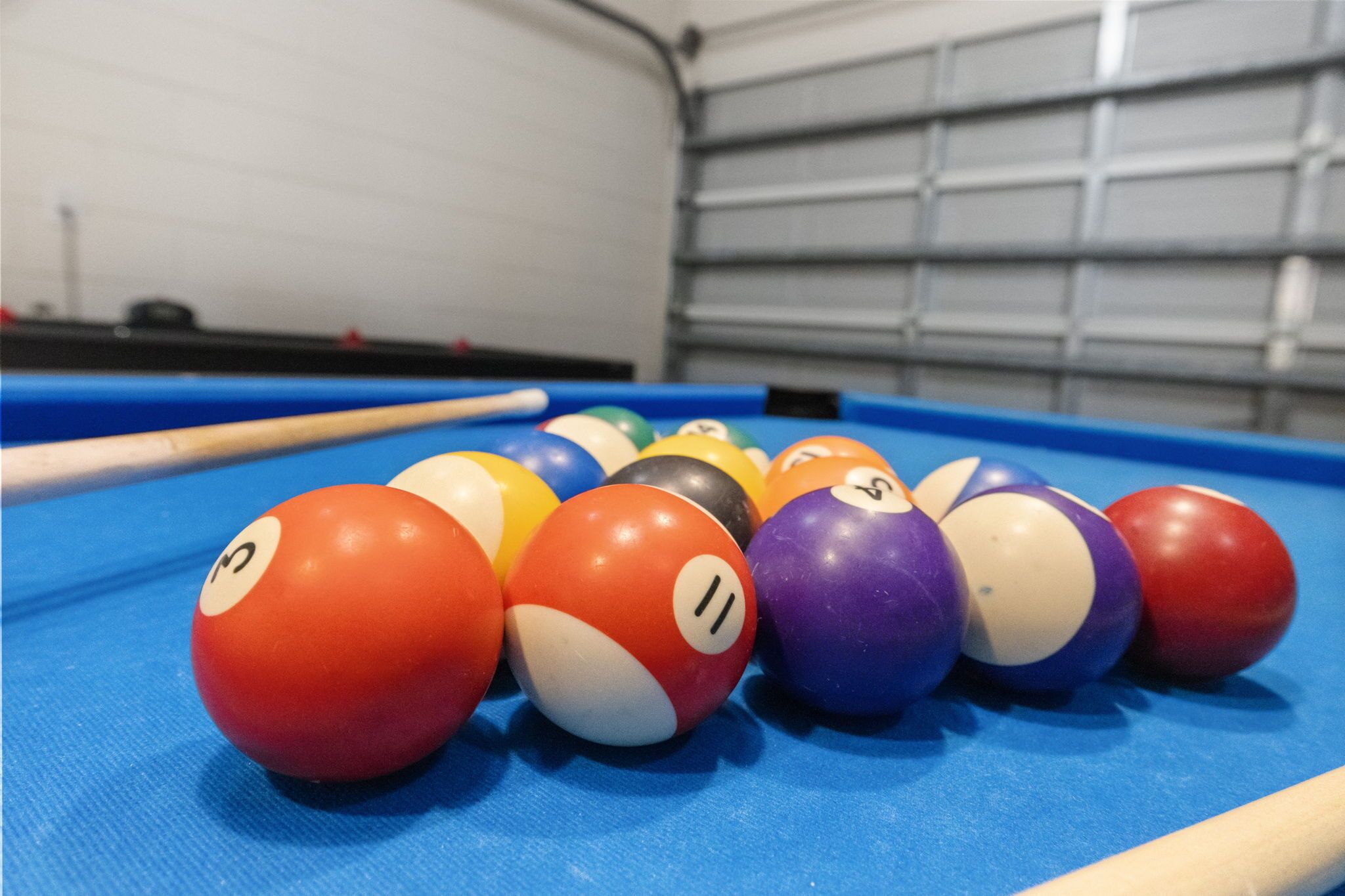 A pool table with billiard balls arranged in a triangle formation.