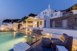 A modern pool area with lounge chairs and a covered seating area. - Venti Villa Naxos (Naxos)