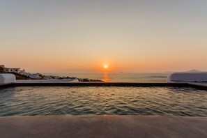 A pool with a sunset view, white buildings, and calm water. - Venti Villa Naxos (Naxos)