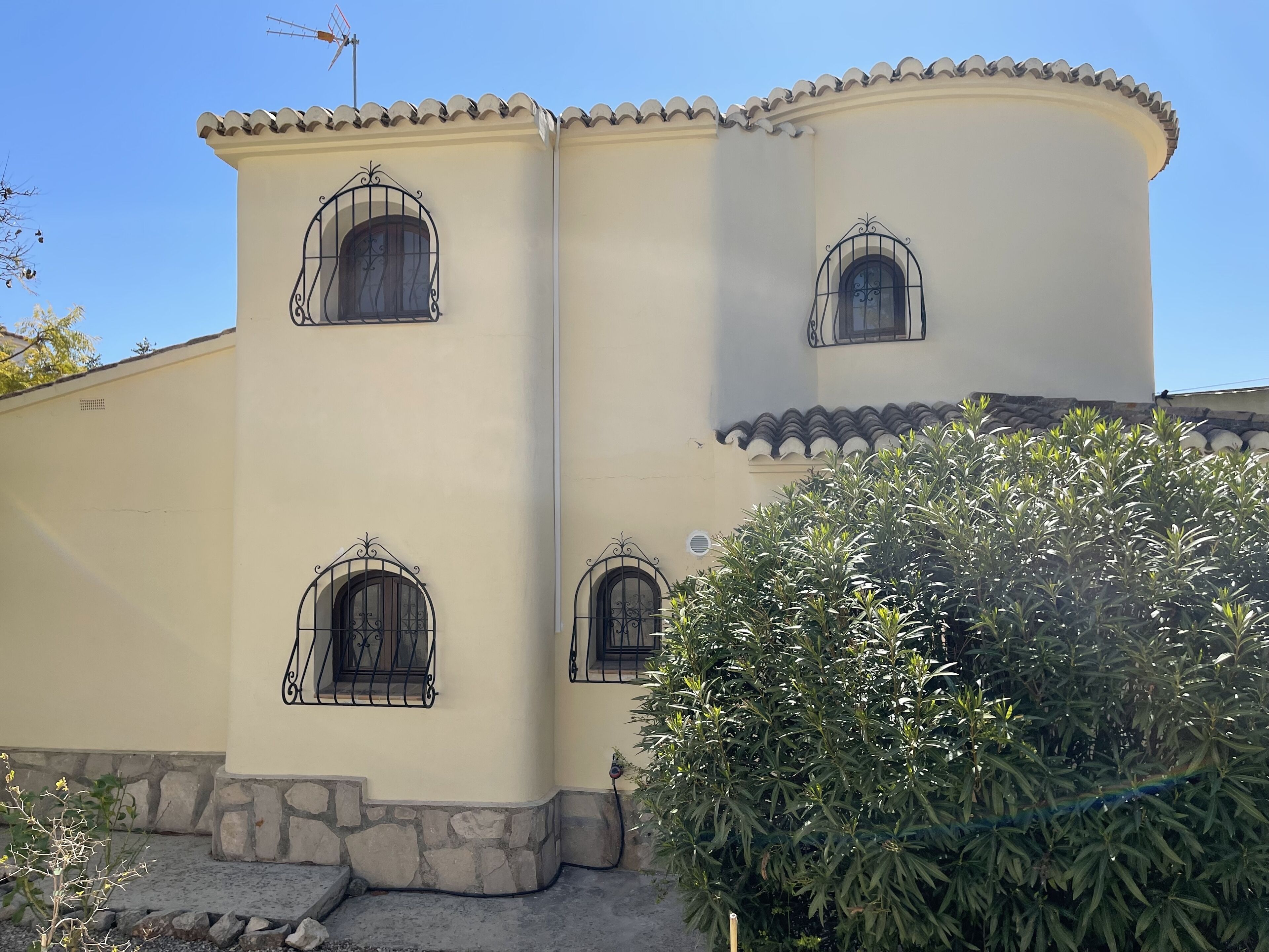 A building with three arched windows and a stone base.