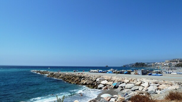 A coastal beach with rocky shorelines, boats, and umbrellas. - HOLIDAYS WITH SEA AND MOUNTAIN VIEWS (ALMUÑECAR - GRANADA)