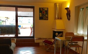Un coin repas avec une table et des chaises, un élément décoratif mural, une horloge et une vue par la fenêtre.
