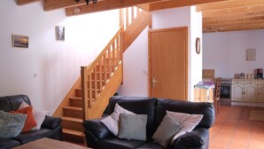 A living room with a staircase, a dining area, and a kitchen. - Traditional Breton Longere, Cotes d'Armor (La Chapelle-Neuve)