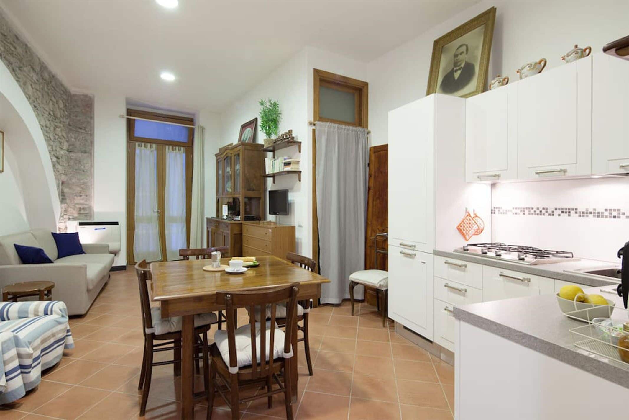 A compact living space with a dining area, kitchenette, and a living room.