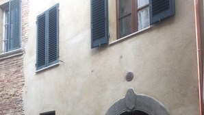 Ein Gebäude mit einer großen Holztür, einem kleinen Fenster mit Metallgitter und einem Schild mit der Nummer 8.