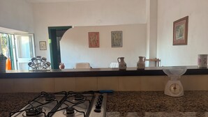 A kitchen with a gas stove, granite countertop, two decorative pitchers, and a scale. - Sea house, garden with a view (Tropea)