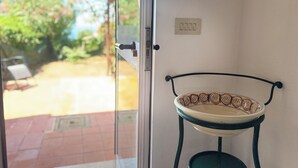 A room with a sliding glass door leading to an outdoor area with a patio and a chair. - Sea house, garden with a view (Tropea)