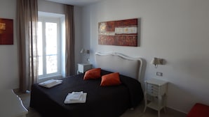 A hotel room with a bed, two bedside tables, a window with curtains, and a wall-mounted artwork. - 3 beds/3 baths, 3 min. walking to the Vatican Museums, metro station, FREE WIFI (Roma)