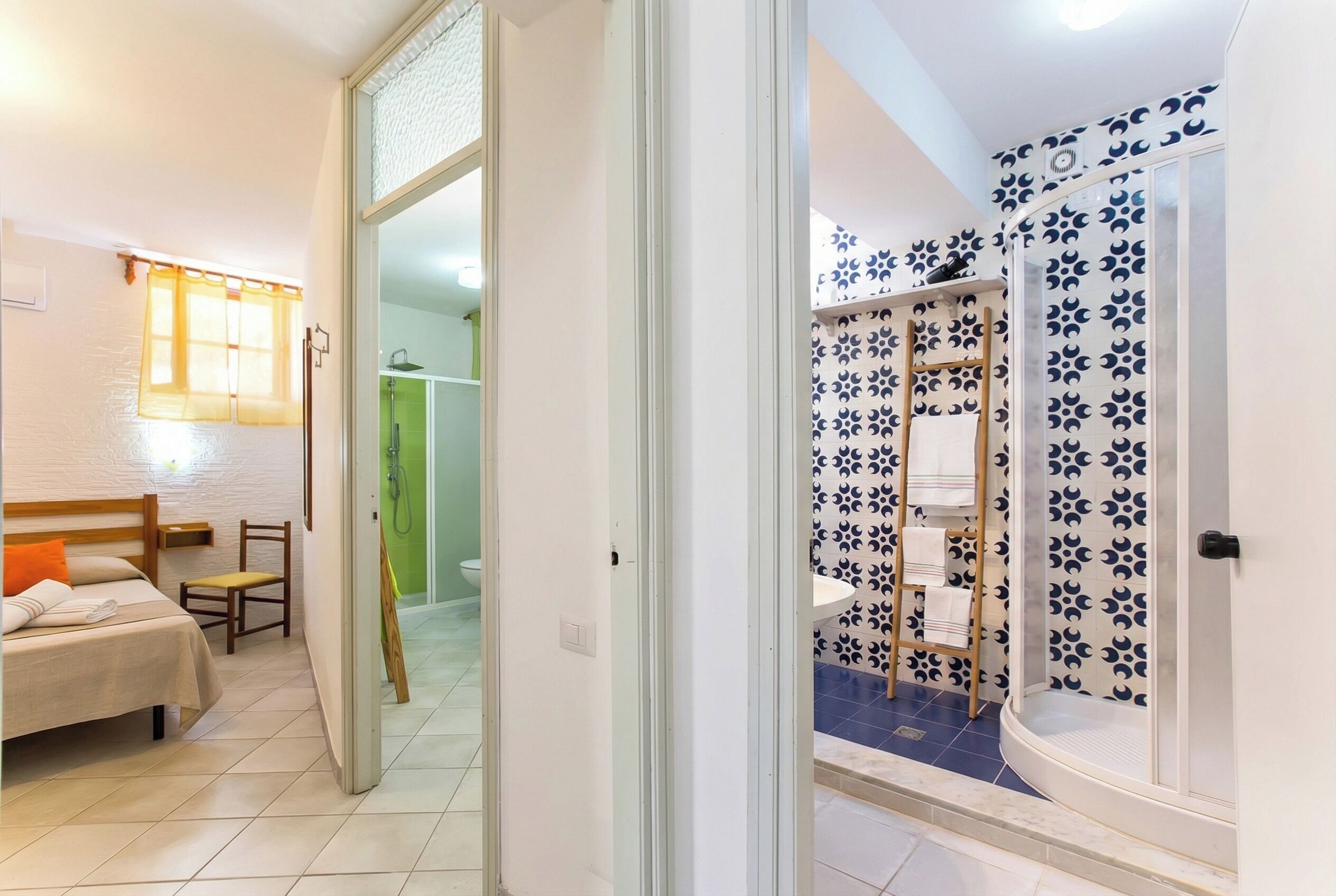 A hotel room with a bed, a chair, a bathroom with a shower and a toilet.