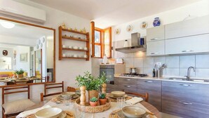 Une cuisine moderne avec des meubles en bois, un four encastré et une grande fenêtre.
