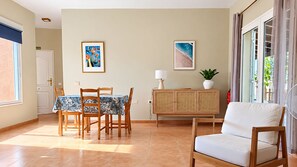 A dining area with a table and chairs, a cabinet, and a sofa. - Casa Nico: Among Gardens and Sunsets (Antigua)