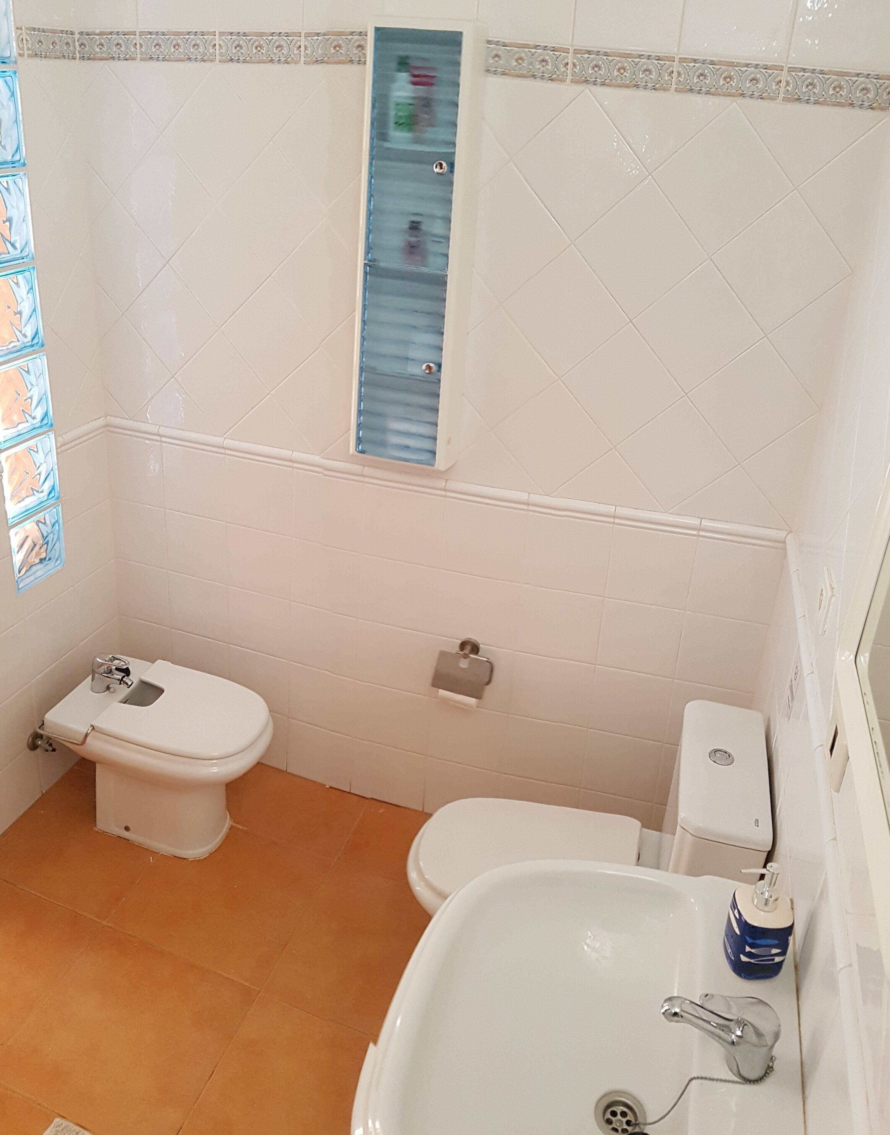Un baño con inodoro, bidé y lavamanos.