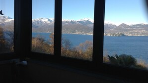 A view through a window of a lake with mountains in the background.