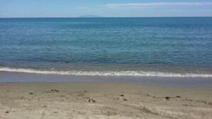 Una playa con vista despejada al océano y una montaña lejana.