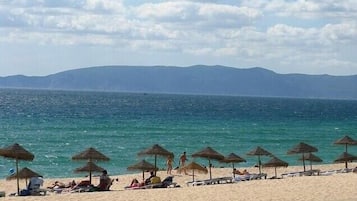 Guests can enjoy stunning ocean views and relax under the shade of thatched umbrellas.
