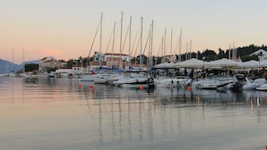 A marina with multiple boats docked, a few umbrellas, and buildings in the background. - STUNNING TRANQUIL  VILLA WITH PRIVATE POOL CENTRAL LOCATION OF THE ISLAND (Sami)