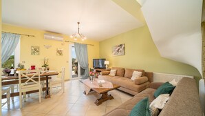 A living room with a sofa, a coffee table, and a dining area with a table and chairs. - STUNNING TRANQUIL  VILLA WITH PRIVATE POOL CENTRAL LOCATION OF THE ISLAND (Sami)