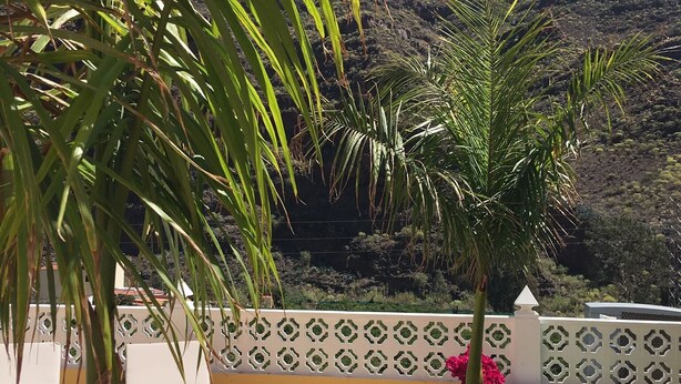 A terrace with lounge chairs and a decorative fence, overlooking a mountainous landscape. - Modern Villa With Stunning Mountain Views (Mogan)