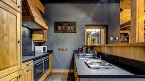 Une cuisine avec des meubles en bois, un four à micro-ondes, un évier et une enseigne indiquant « Café Bistro ».