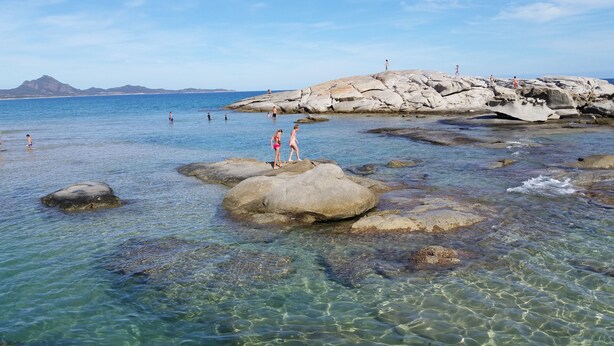 A rocky beach with clear water and people walking on rocks. - Splendid Sea View Villa with Privacy and Garden, Just 700m from the Beach! (Costa Rei)