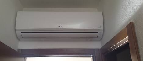 A white LG inverter V air conditioner mounted on a wall.