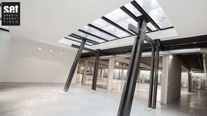 A spacious, modern interior with a high ceiling and skylights, featuring exposed structural beams and a clean, minimalist design. - Elegant house in the center of Rome-Parioli a stone's throw from Via Veneto (Roma)